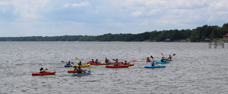 4-H campers paddling in kayaks on a lake